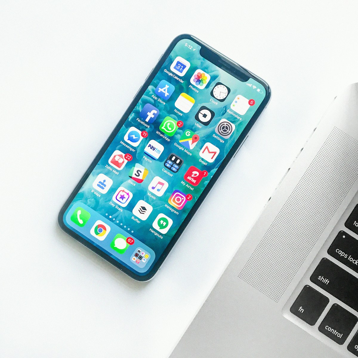Smartphone on a bright tabletop beside a laptop