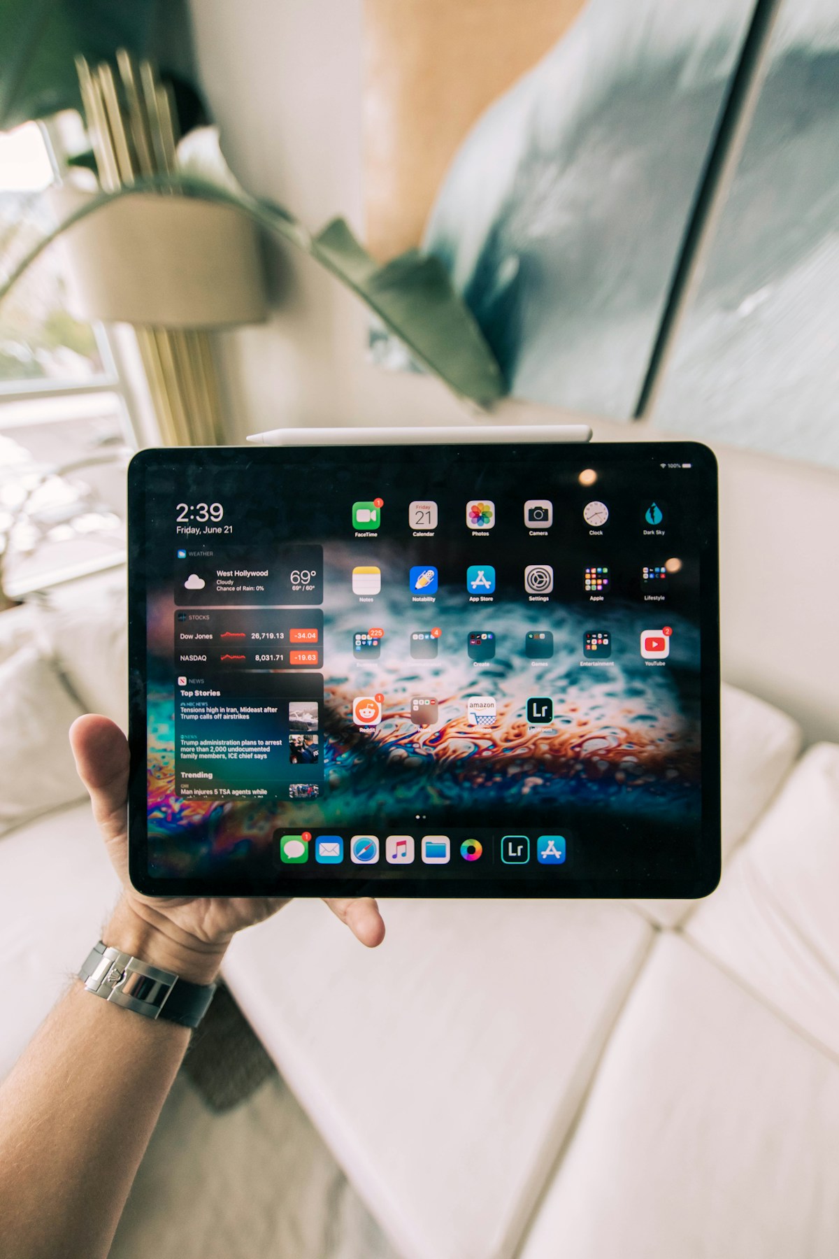 A tablet held in front of a softly lit room