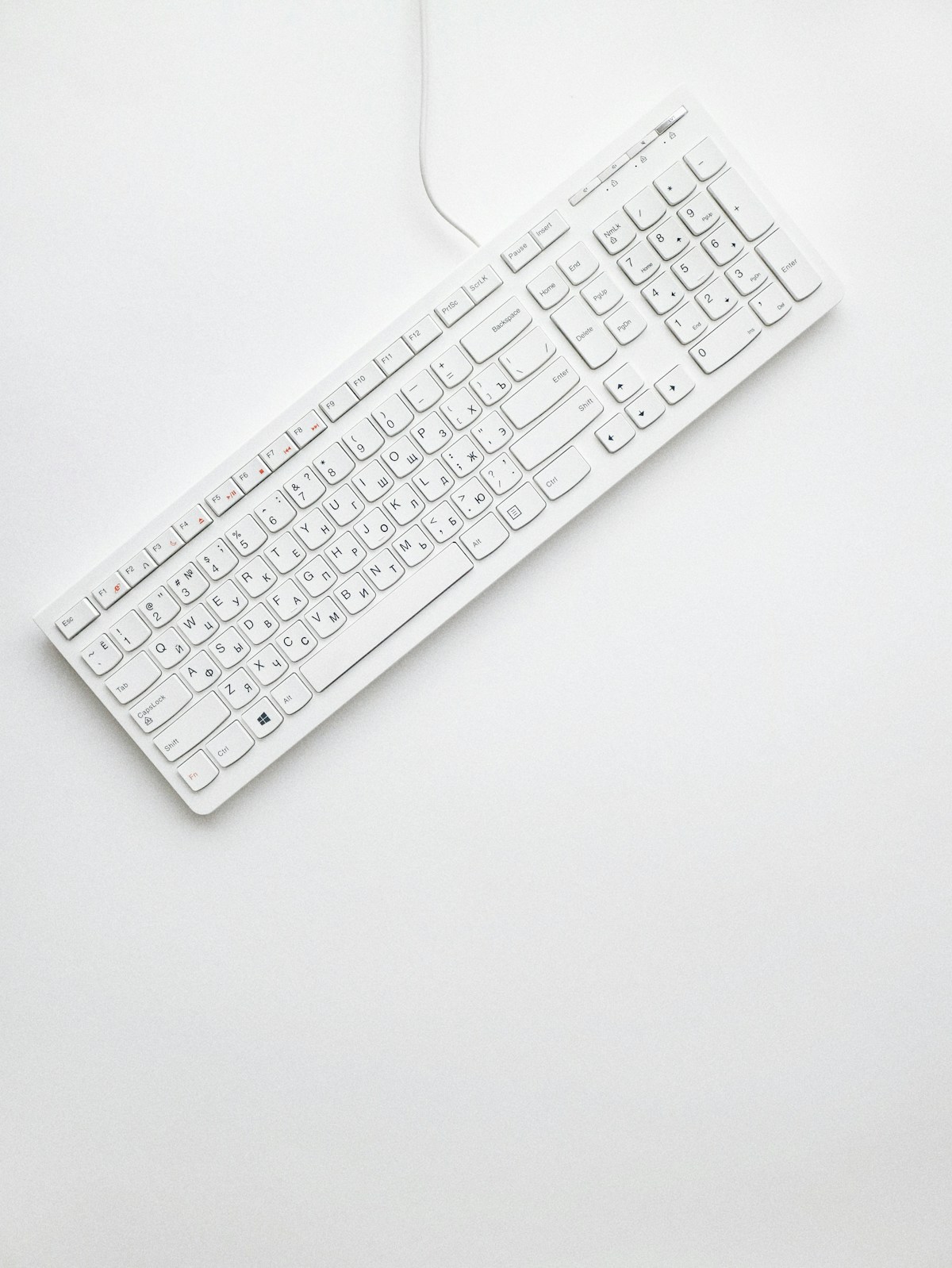 A white wireless keyboard on a clean surface