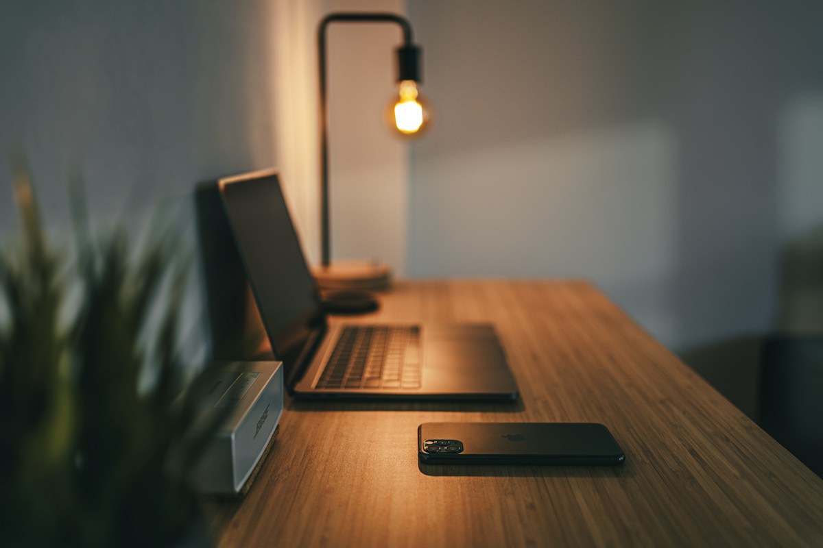 Warm desk lamp illuminating a wooden workspace